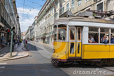 Very touristic place in the old part of Lisbon, with a traditional tram passing by in the city of Lisbon, Portugal. Editorial Stock Photo